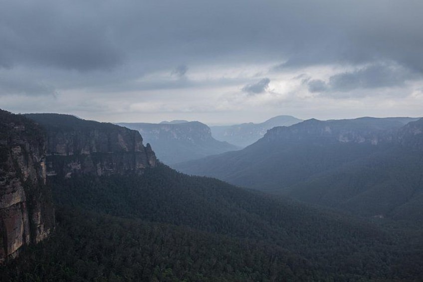 Un paisaje montañoso con riscos escarpados y un bosque denso. 5