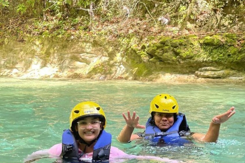 Twee mensen in een rivier, uitgerust met helmen en reddingsvesten. 2