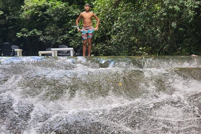 A person standing on a rock with water flowing around them. 4
