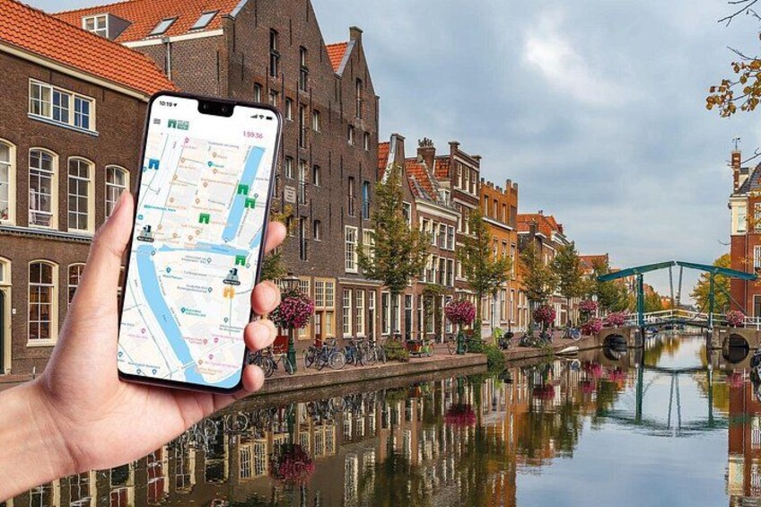 A hand holding a smartphone with a map application, a canal, traditional buildings, and a bridge. 1