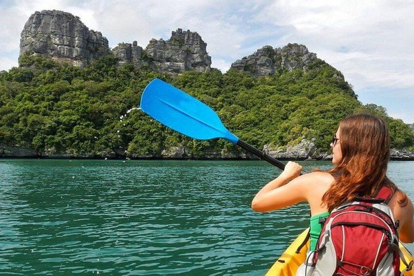 A person kayaking on a calm body of water with a mountainous landscape in the background. 3