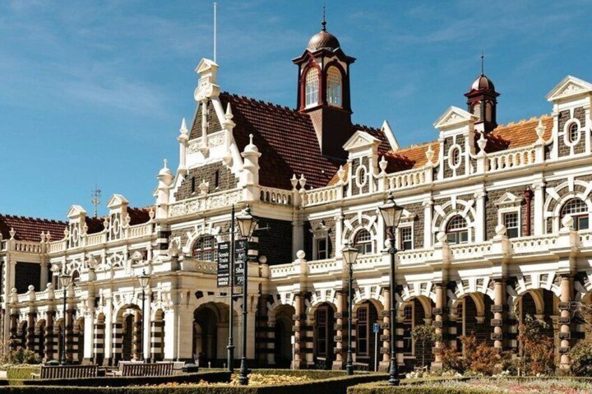Un edificio grande y ornamentado con tejado de tejas rojas y varias torres. 2