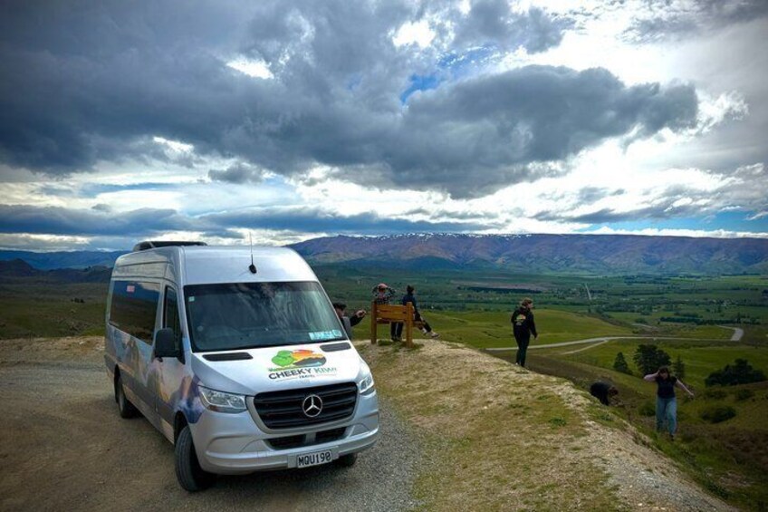 Una camioneta blanca estacionada en un camino de tierra con un paisaje montañoso al fondo. 5