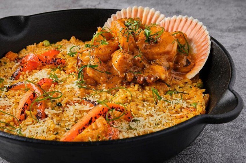 A skillet with a seafood and rice dish, garnished with herbs. 5