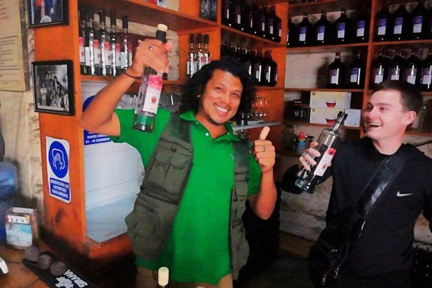 A person holding a bottle of liquor, another person with a bottle, and a shelf with various bottles in a bar setting. 4