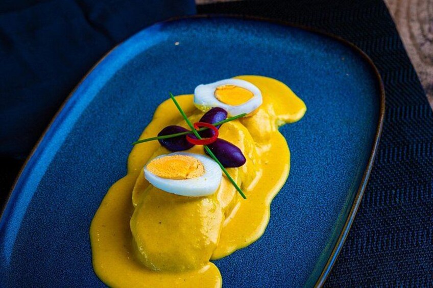 A dish with yellow sauce, egg halves, and purple garnish on a blue plate. 2