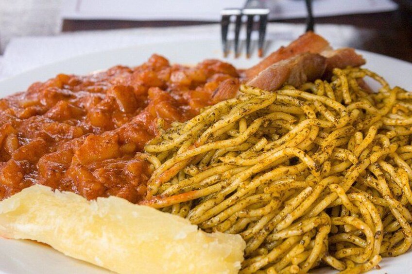 A plate of spaghetti with tomato sauce, a piece of bread, and a piece of meat. 3