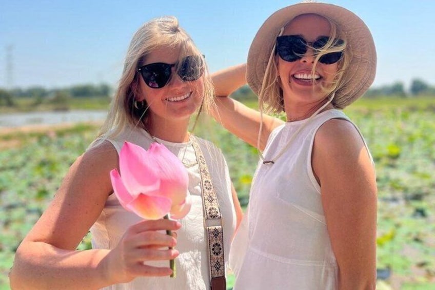 Two people in a field with a lotus flower. 1