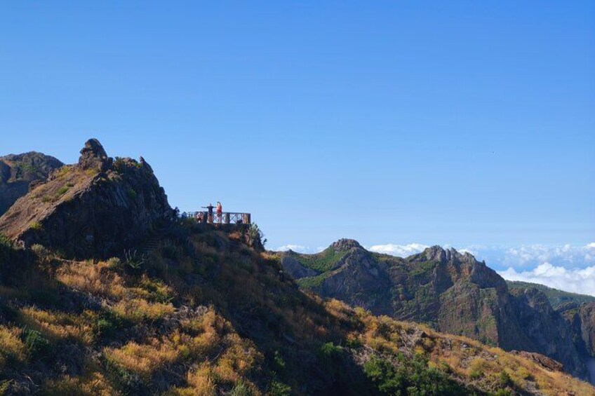 A mountainous landscape with a rocky outcrop and a viewing platform. 3