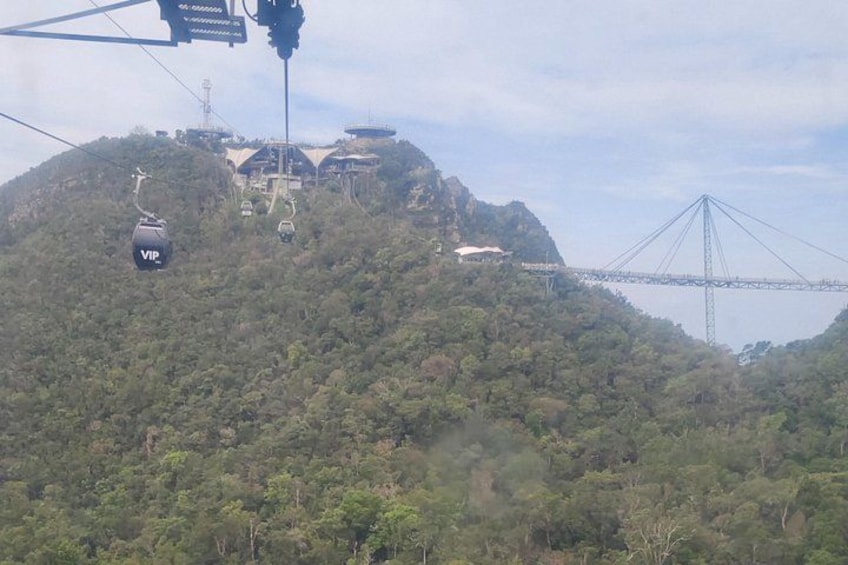 Un téléphérique, un pont et un paysage montagneux. 5