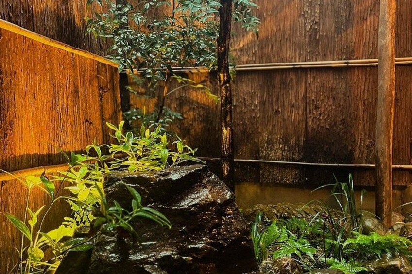 Een houten constructie met een klein waterpartij en groen. 2