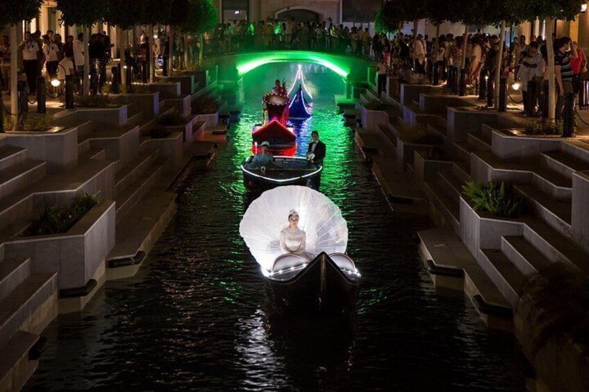 En kanal med båtar, trappsteg och en folkmassa. 3