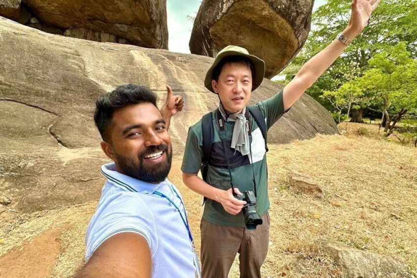 Dos personas tomándose un selfie con una gran formación rocosa de fondo. 2