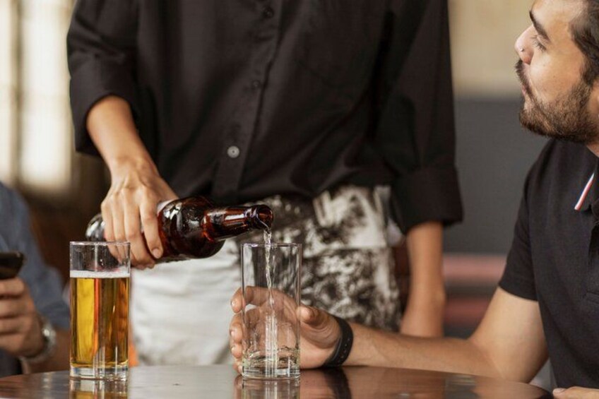 A person pouring a dark liquid into a glass. 5