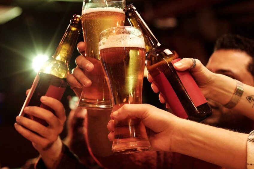 People holding glasses and bottles, likely in a social setting. 2