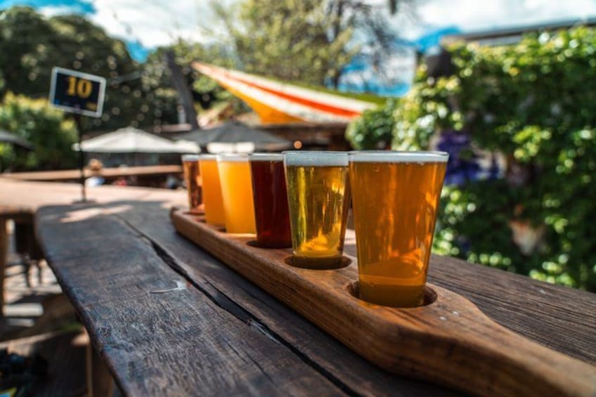 A wooden table with four glasses of beer. 3