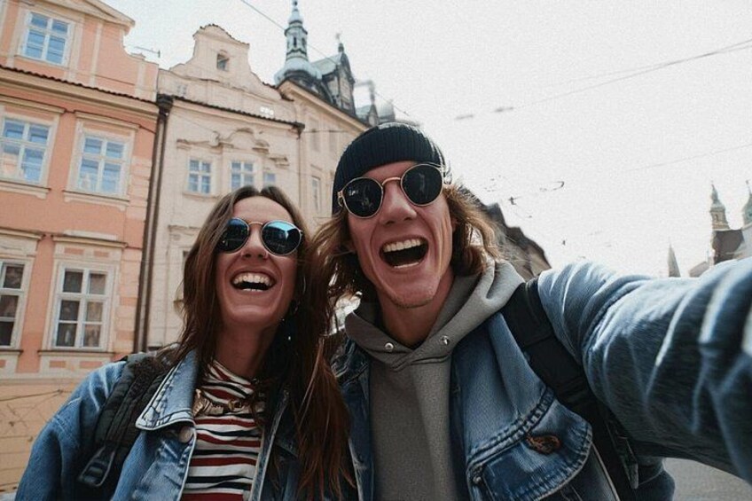 Two people taking a selfie with a historic building in the background. 3