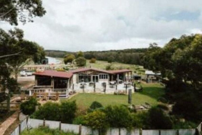 A large house with a red roof, surrounded by a fenced yard and lush greenery. 2