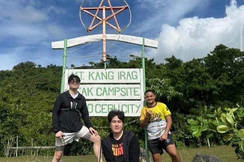 Three people posing in front of a sign for Mt. Kang Irag, Kak Campsite, and Cerubity. 5