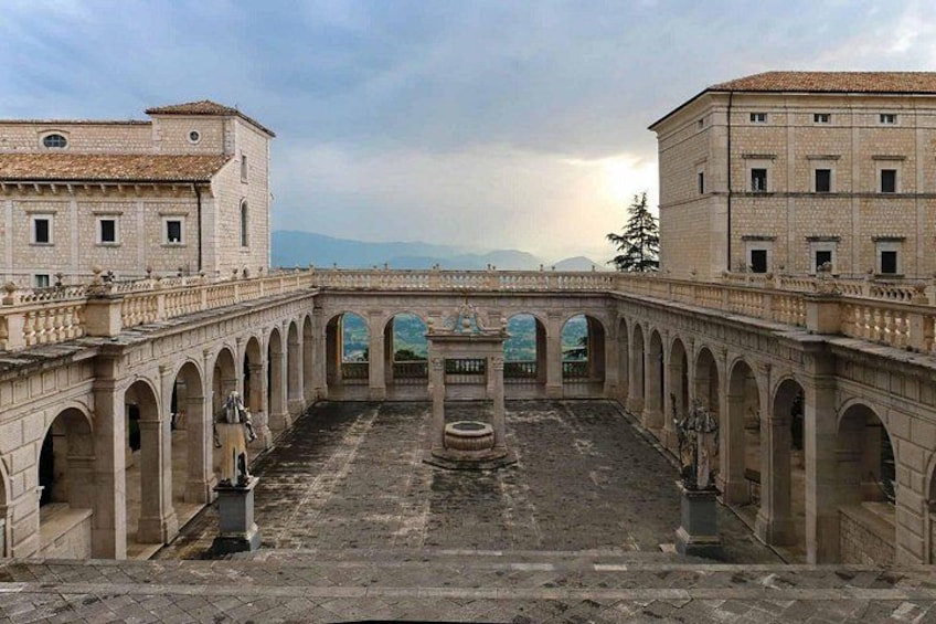A courtyard with a central fountain, surrounded by arches and buildings. 3