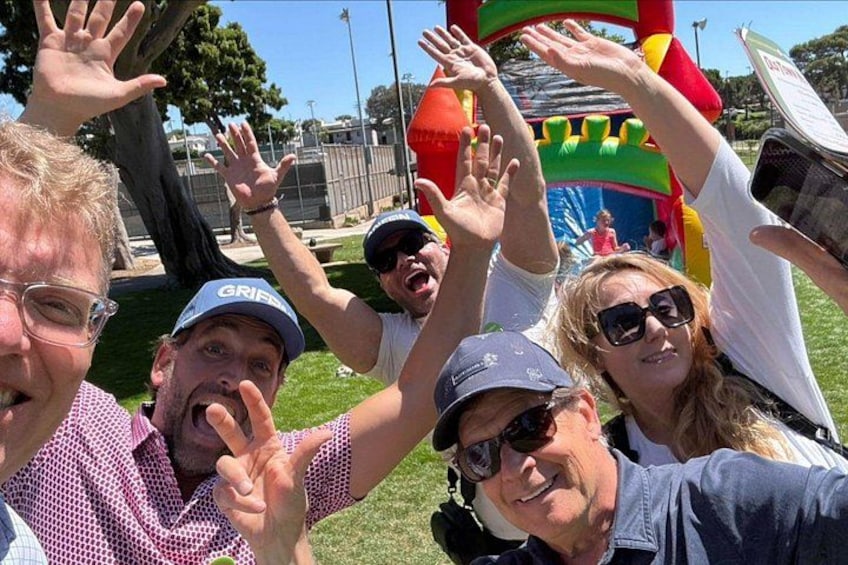 A group of people outdoors with a colorful inflatable structure in the background. 2