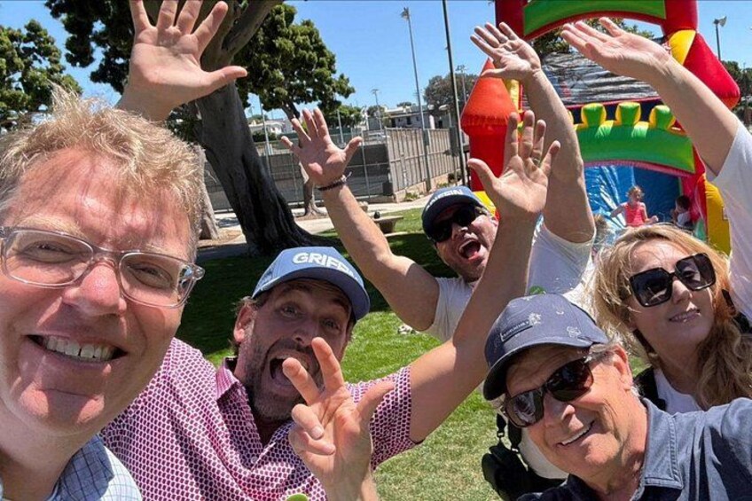 A group of people at a park with a colorful inflatable structure in the background. 4