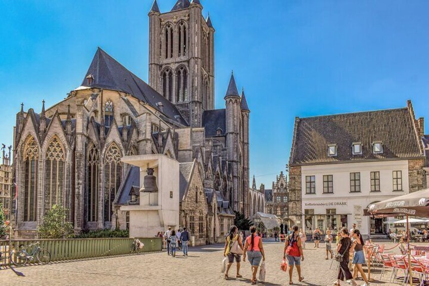 Una iglesia histórica de arquitectura gótica, una plaza de mercado con gente y bicicletas, y edificios tradicionales. 3