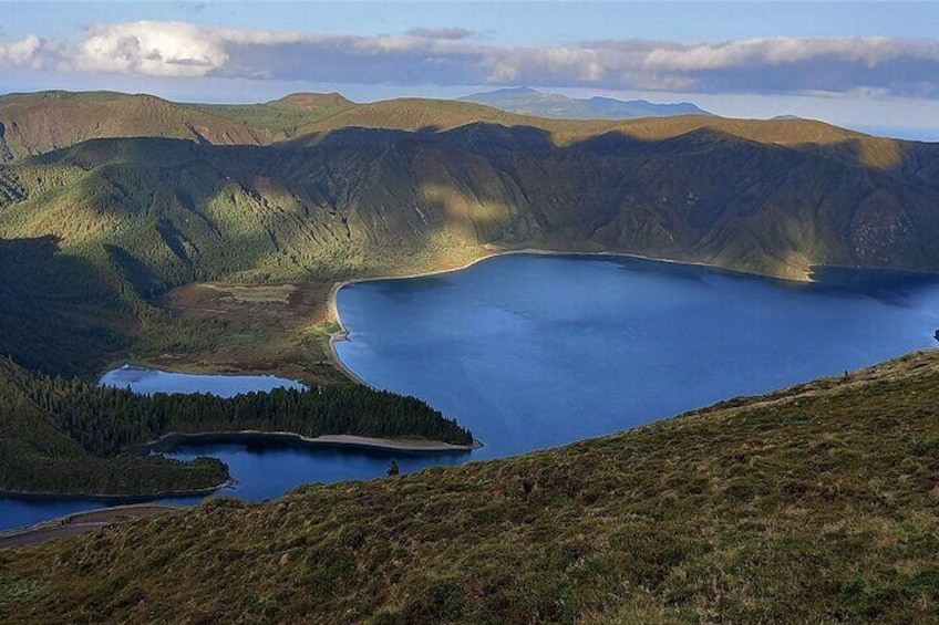 A lake surrounded by mountains and forested areas. 3