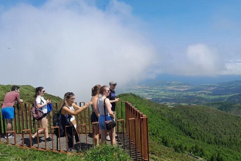 A group of hikers on a wooden observation deck overlooking a mountainous landscape. 4