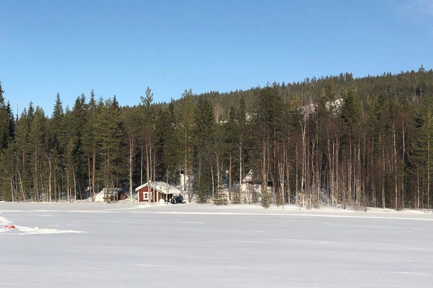 A snowy landscape with a red cabin and a forest in the background. 3