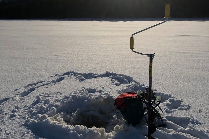 A snowmobile on a frozen lake with a snow-covered area and a yellow object in the background. 4