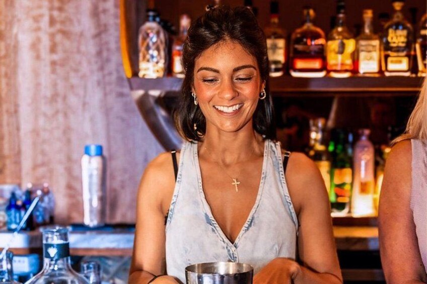 Una persona en un bar, con botellas y vasos. 2