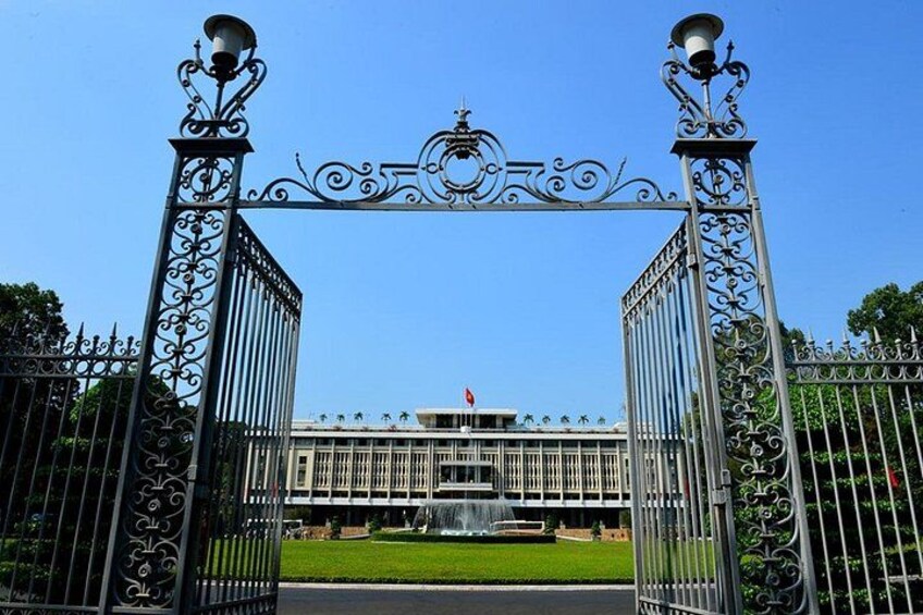 A wrought iron gate with a fountain in the background. 2