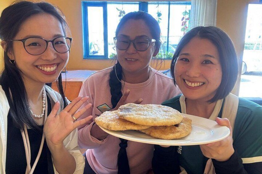 Tre persone che tengono un piatto con del cibo, in una stanza con una finestra e piante. 4