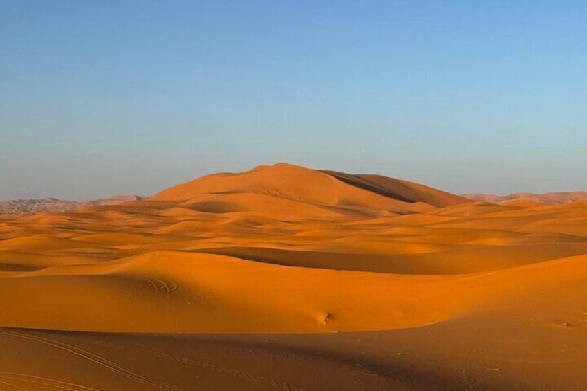 Paesaggio desertico con dune sabbiose che si estendono sotto un cielo sereno. 3