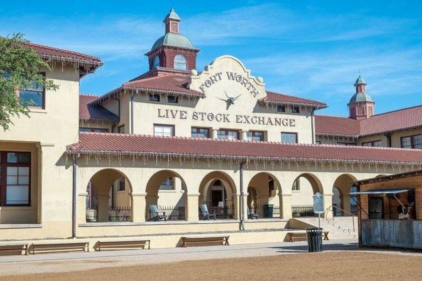 A historic building with arched windows and a sign that reads 'Fort Worth Live Stock Exchange.' 2