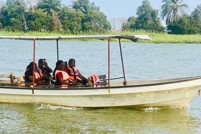 A boat with passengers wearing life jackets on a calm river. 5