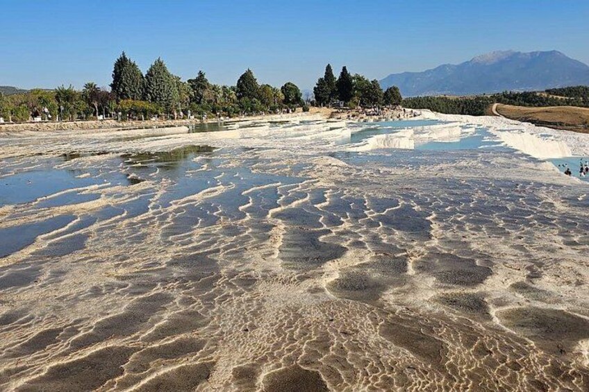 Un área geotérmica con depósitos minerales y cielo despejado. 2