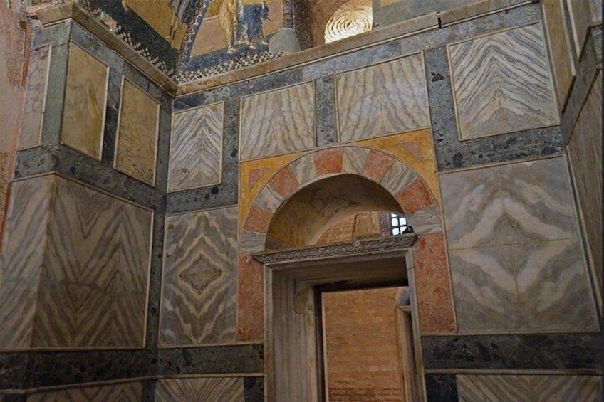 A mosaic with geometric patterns and a wooden door. 2