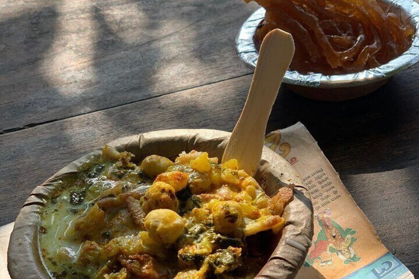 Un bol de comida con una cuchara de madera, un plato de salmón ahumado y un menú sobre una mesa de madera. 5