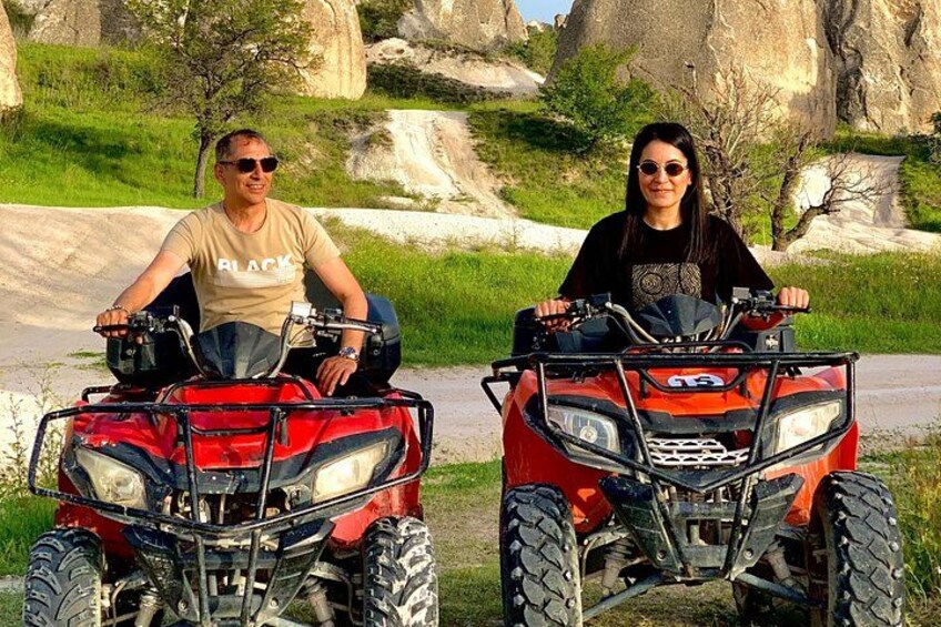 Two people on ATVs in a natural setting with rocks and greenery. 4