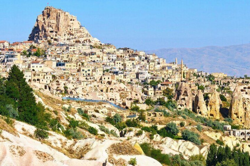Un pueblo con un imponente pico rocoso, edificios en terrazas y formaciones rocosas únicas. 2
