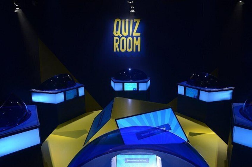 A quiz room with illuminated tables and a neon sign. 3
