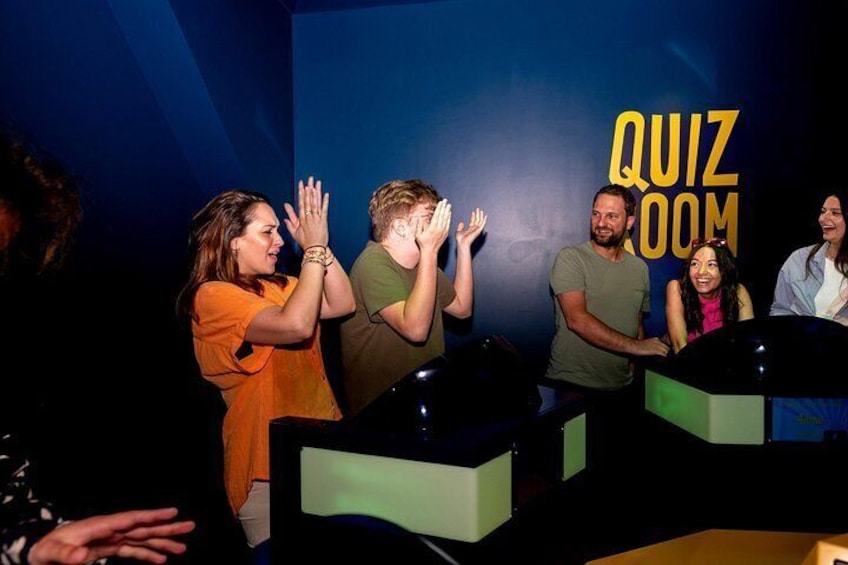 A quiz room with participants clapping and a quiz room sign in the background. 5