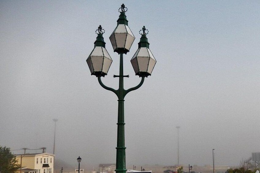 A green street lamp with three lanterns. 2