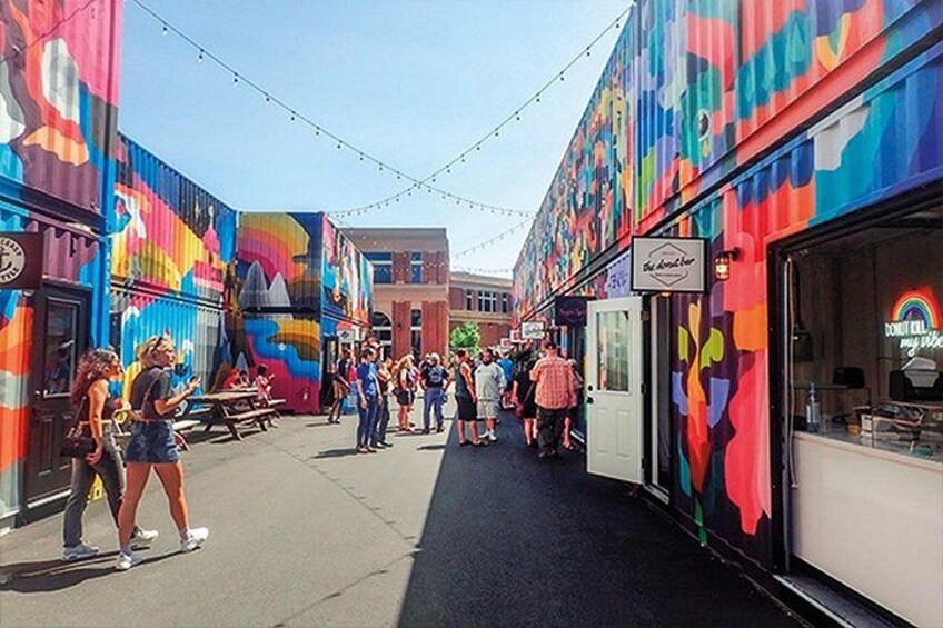 A colorful street with people walking and dining. 4