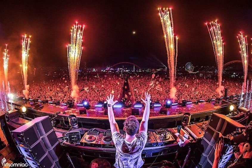 Een concert met een groot publiek, podiumverlichting en vuurwerk. 1
