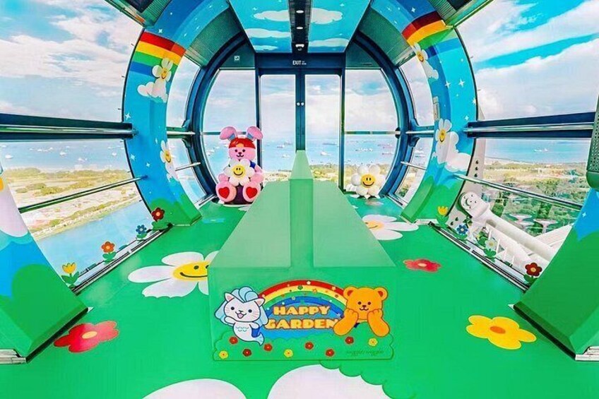 Un espace de jeux coloré pour enfants, avec un sol vert, un ours, un lapin et un panneau en forme d’arc-en-ciel. 2