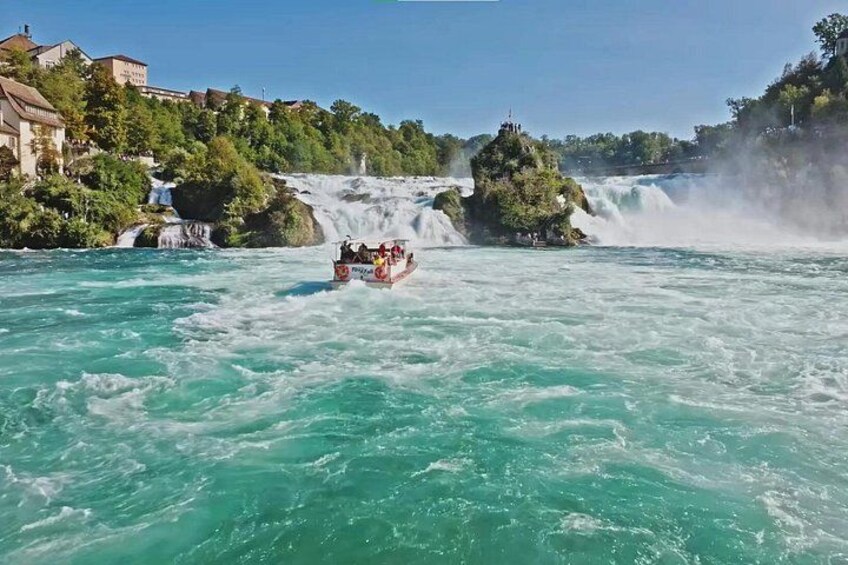 A boat navigating a river with a waterfall in the background. 2