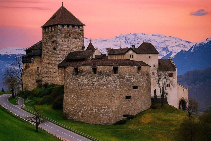 A medieval castle with a tower, surrounded by snow-capped mountains and a winding road. 1